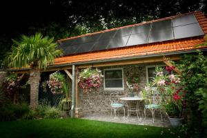 een huis met een tafel en stoelen in een tuin bij Bed and Breakfast Piekoo Belloo in Weert