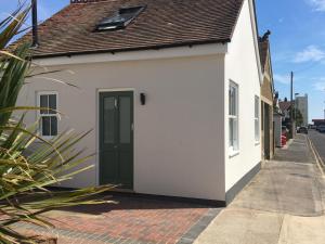a white building with a green door on a street at The Studio in Worthing