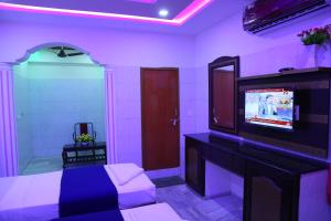 グントゥールにあるHotel Garuda Gunturのベッドルーム1室(ベッド1台、テレビ付)