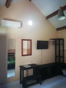 uma sala de estar com televisão na parede em La Casa Homestay em Senggigi