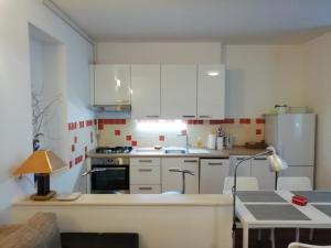 a small kitchen with white cabinets and a table at Apartment A-zone Zagreb in Zagreb