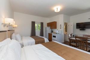 ein Hotelzimmer mit 2 Betten und einem Esszimmer in der Unterkunft Motel au Fleuve d'Argent in Rivière-du-Loup