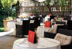 un grupo de mesas y sillas con tarjetas rojas. en La Villa Mazarin, en Aigues-Mortes