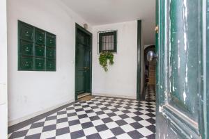 リスボンにあるAlfama Tailor Made Blue House With a View #1の黒いドアとチェックした床の廊下