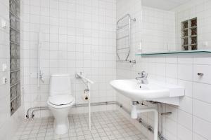 a white bathroom with a toilet and a sink at Hensbacka Hotell in Munkedal +18 photos