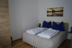 Bett in einem Zimmer mit blauen Kissen in der Unterkunft Villa Karin in Adnet