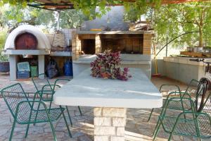 a table and chairs in a patio with a fireplace at Athina Rooms in Agios Andreas
