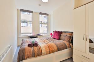 a bedroom with a bed and two windows at The Nest in Sheffield
