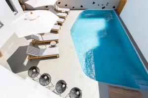 vista sulla piscina con sedie a sdraio e piscina di Aegean Gem a Kamari
