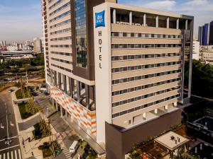 um edifício branco alto com um cartaz em ibis budget Sao Bernardo do Campo em São Bernardo do Campo