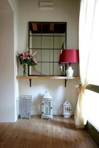 a room with a mirror and a vase of flowers at La Corte Di Anna Agriturismo in San Giovanni Lupatoto