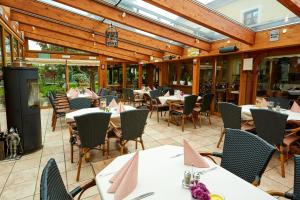 ein Restaurant mit Tischen und Stühlen auf einer Terrasse in der Unterkunft Hotel Am Eifelsteig in Neroth