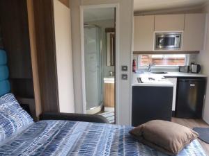 a room with a kitchen and a bed with a pillow at The Swan Suite in Belford