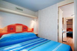 ein Schlafzimmer mit einem blauen Bett in einem Zimmer in der Unterkunft Villaggio Azzurra in Termoli
