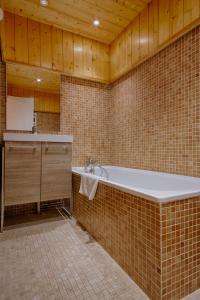 a bathroom with a bath tub and a sink at Hotel Résidence Le Sporting in Cap-Ferret