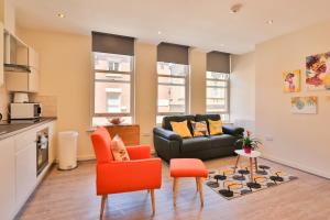 sala de estar con sillas de color naranja y sofá en The Nest en Sheffield