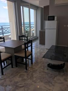 a kitchen with a table and chairs and a refrigerator at Golden Sea View Penthouse in Pomorie