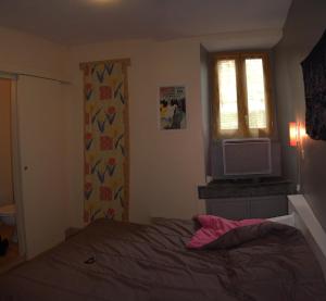 a bedroom with a bed and a window and a television at Appartement proche station in Luchon