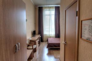 Habitación con cama y escritorio. en Hotel Aviator, en Ufa