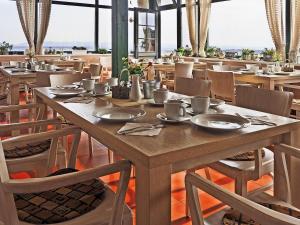 a dining room with a wooden table and chairs at Hotel Vinohrad in Milotice