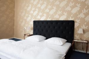 a bedroom with a large bed with a black headboard at Matejki 8 in Szczecin