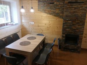 a room with a table and chairs and a fireplace at Domek 87 in Krynica Zdrój