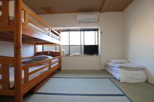 a bunk bed room with two bunk beds and a television at Furusatono Ie in Kyoto