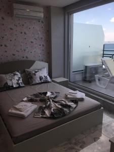 a bed in a room with a large window at Golden Sea View Penthouse in Pomorie