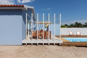 un groupe de chaises assises sur une terrasse à côté d'une maison dans l'établissement Blue Dreams, à Ovar