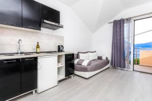 een keuken met een wastafel en een bank met een raam bij SSM Apartmani in Kotor