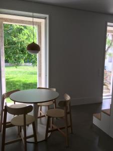 a dining room with a table and chairs and a window at Trafaria Garden Beach Houses in Trafaria