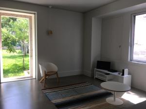 a living room with a table and a window at Trafaria Garden Beach Houses in Trafaria