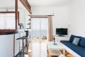 ピレウスにあるHolodek Apartments : Kastellaのリビングルーム(青いソファ、テーブル付)