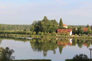 a house is reflected in the water of a lake at Penzion Hejtman in Chlum u Třeboně