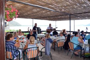 a group of people sitting in chairs at tables at Apartmani Konoba Starčevo in Virpazar