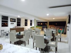 a restaurant with white chairs and tables in a room at Confiance Hotel in Crateús