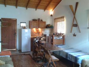 a kitchen with a wooden table and a refrigerator at The House of Summer Winds in Évdhilos