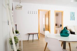 a white dining room with a white table and chairs at Apto Redes Museo in Seville