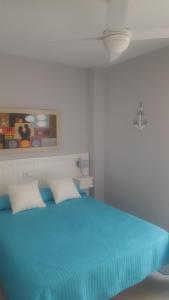 ベナルマデナにあるEdificio Andalucia 2 Costa del Solのベッドルーム1室(青いベッド1台、枕2つ付)