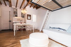 een woonkamer met een witte bank en een tafel bij Charming 30m² border of MONTMARTRE in Parijs
