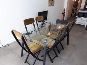 a glass table and chairs in a living room at Cosy 30m² DENFERT-ROCHEREAU district in Paris