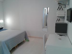 a bedroom with a bed and a desk with a television at I Gelsomini in Melfi