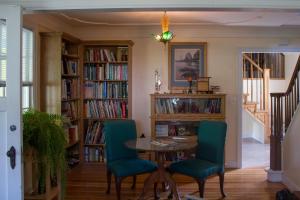 a dining room with a table and chairs and bookshelves at Genelle House B&B Guest House in Genelle
