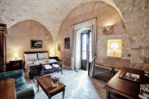 チェーリエ・メッサーピカにあるLuxury Villa Masseria Beneficioの城内のベッドルーム(ベッド1台、ソファ付)