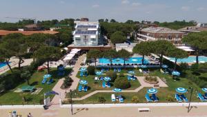 einen Luftblick auf einen Park mit blauen und weißen Sonnenschirmen in der Unterkunft Park Hotel Ermitage Resort & Spa in Lido di Jesolo