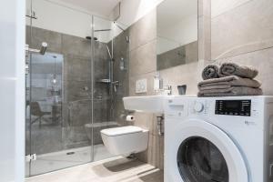 a bathroom with a washing machine and a shower at Parkside Boutique Appartements in Herbolzheim +51 photos