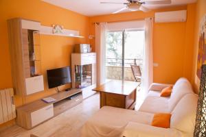 sala de estar con sofá y TV en Apartamento con encanto junto a la playa y en el centro del pueblo, en La Herradura