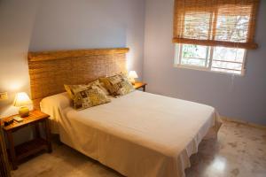 1 dormitorio con 1 cama blanca grande y 2 lámparas en Apartamento con encanto junto a la playa y en el centro del pueblo, en La Herradura