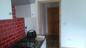 a kitchen with a stove and a red brick wall at Murrevagh Mealog in Tooreen