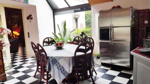 a kitchen with a table with chairs and a refrigerator at Chez Herveline Le Fer - Chambres et table d'hôtes in Plouigneau